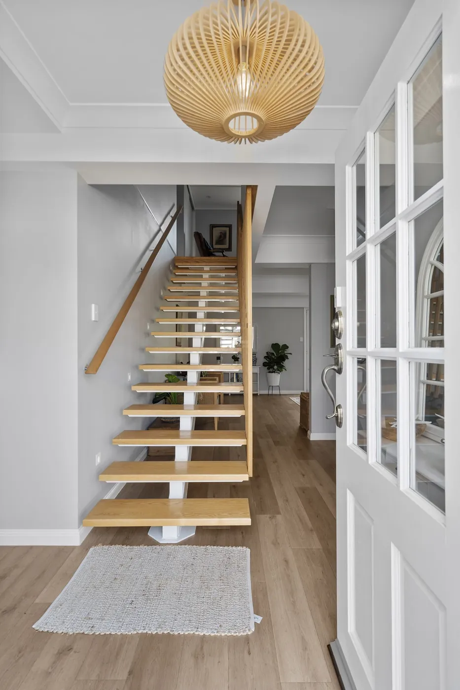 Timber staircase framed by white walls and glazed internal doors.