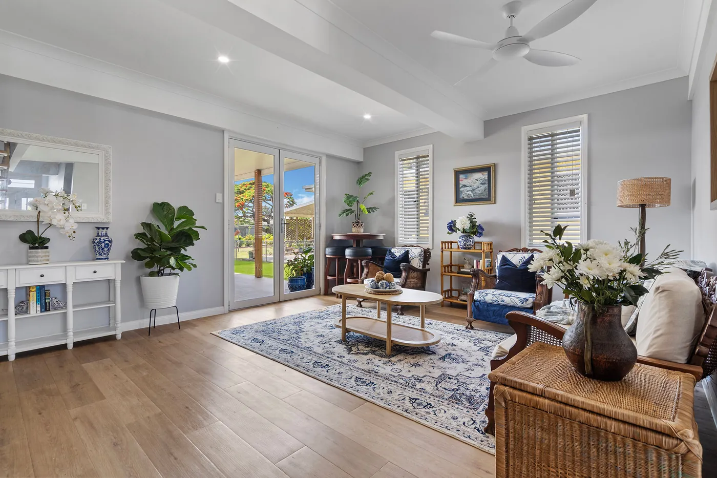 Light-filled lounge with glazed doors, timber flooring and views into the garden.